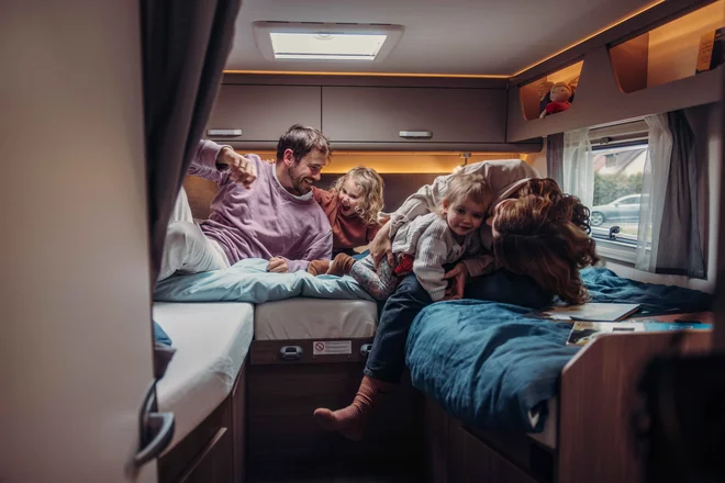 Familia de 4 personas disfrutando del conford de una autocaravana de alquiler en Valencia